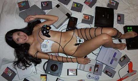 A poil au mileu de sa collection de jeux videos - geekette sexy une fille nue au milieu d une collection de manettes consoles et jeux videos